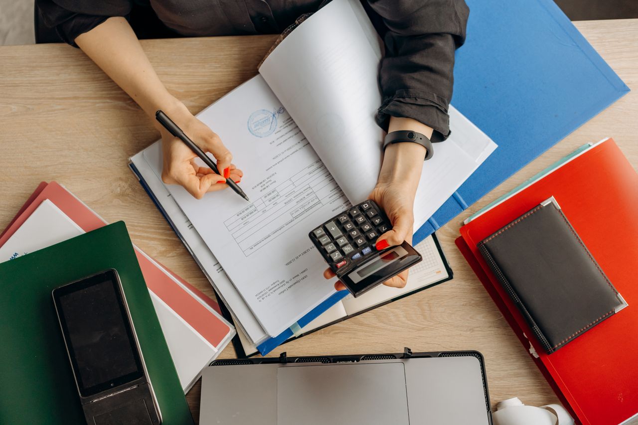 Buchhalter analysiert Finanzdokumente mit einem Taschenrechner